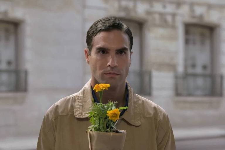 Homem segura vaso com flores amarelas