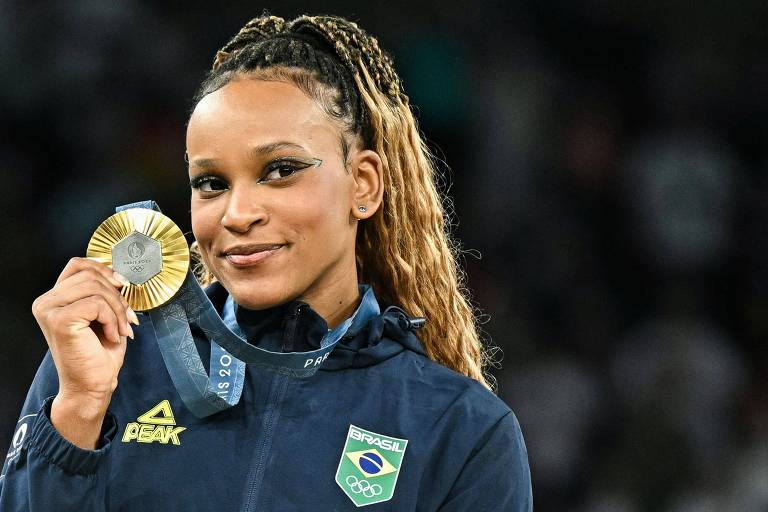 A brasileira Rebeca Andrade mostra a medalha de ouro na Arena Bercy depois de triunfar no solo da ginástica artística nas Olimpíadas de Paris-2024