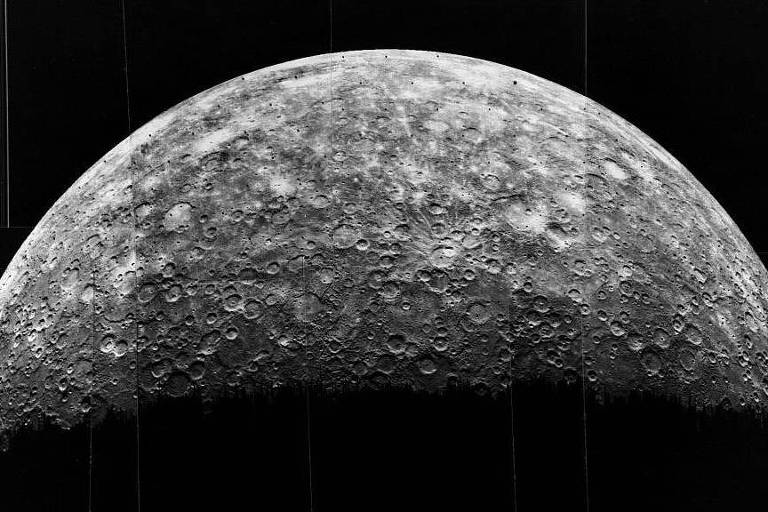 A imagem, em preto e branco, mostra meio planeta (Mercúrio) com suas crateras
