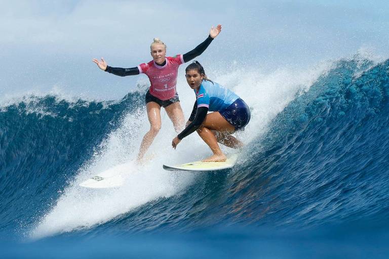 No mar do Taiti, em semifinal olímpica, a brasileira Tatiana Weston-Webb e Brisa Hennessy, da Costa Rica, pegam a mesma onda; a brasileira ergue os braços reclamando porque a rival não respeitou a prioridade dela