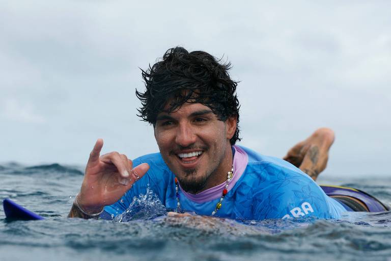 Sorrindo e dentro do mar, Gabriel Medina comemora a conquista do bronze no surfe de Paris-2024 nas águas do Taiti (Polinésia Francesa)