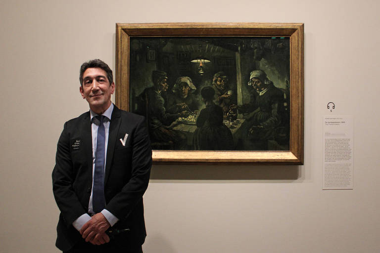 O segurança Mohammed Boukhrouf com a obra "Os Comedores de Batatas", de Van Gogh, no museu dedicado ao artista