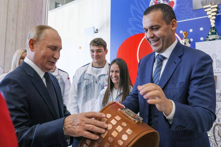 O presidente da IBA, Umar Kremlev, entrega um cinturão premiado ao presidente russo, Vladimir Putin, na inauguração de um centro de boxe em Moscou em setembro de 2022