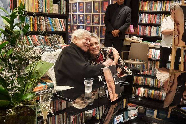 Em foto colorida, um homem e uma mulher abraçam para foto