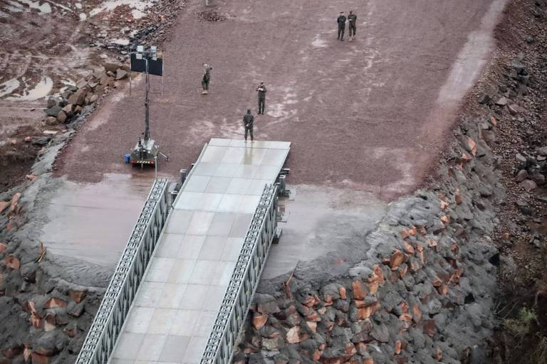 Na foto, algumas pessoas estão próximas ao acesso de uma ponte