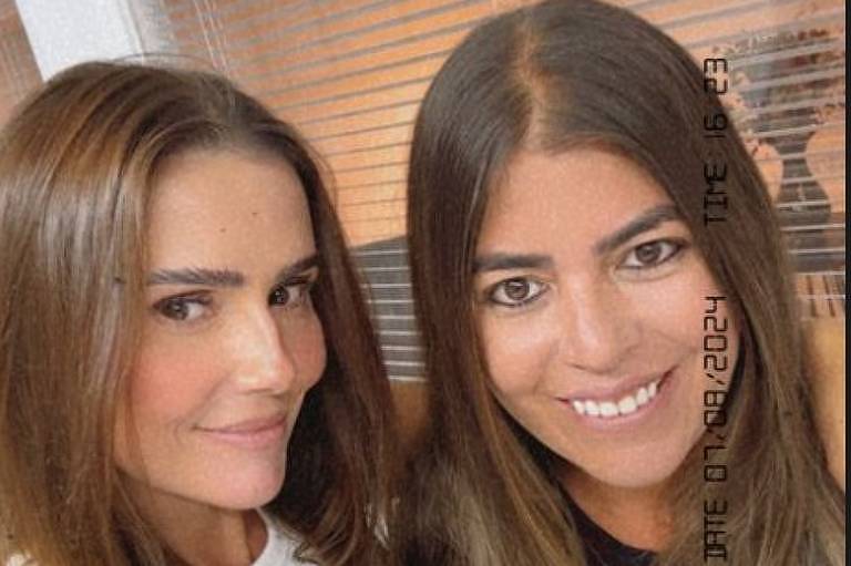 Em foto colorida, duas mulheres se encontram e fazem fotos juntas
