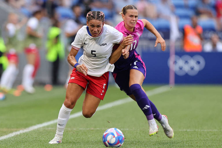 Trinity Rodman, da seleção de futebol dos EUA, passa pela marcação da alemã Klara Buehl na semifinal das Olimpíadas de Paris