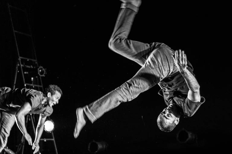 Foto em preto e branco de dois bailarinos no ar