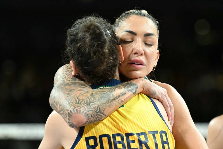 Com os olhos fechados, a atacante Thaísa, que o braço direito todo tatuado, abraça a levantadora Roberta na Arena Paris 1 depois da conquista do bronze pela seleção brasileira de vôlei nas Olimpíadas de Paris