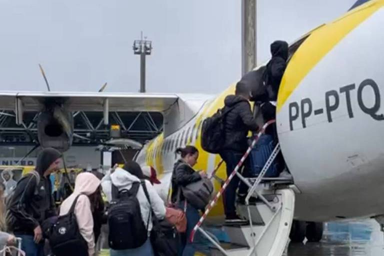 Passageiros com malas sobem escada para embarcar em aeronave