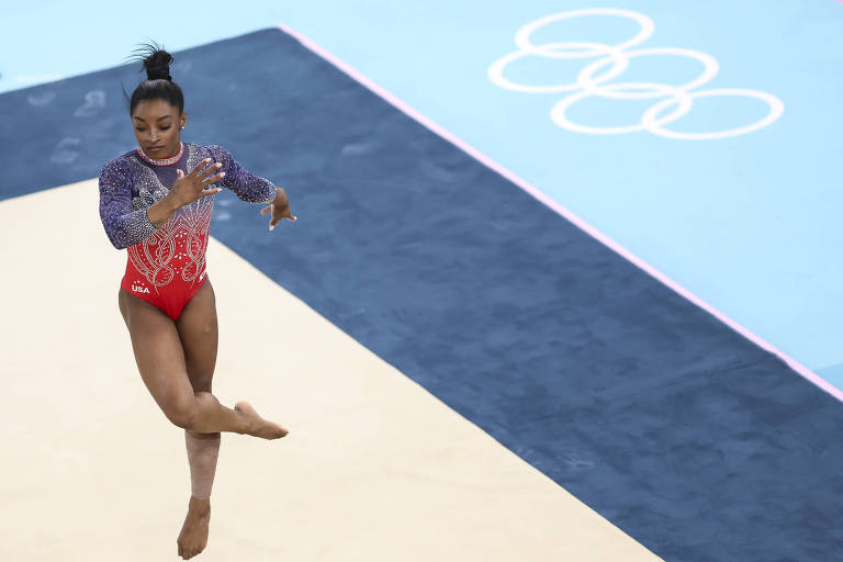 A norte-americana Simone Biles faz um movimento com as pernas cruzadas em sua apresentação na final do solo da ginástica artística nos Jogos Olímpicos de Paris, na Arena Bercy