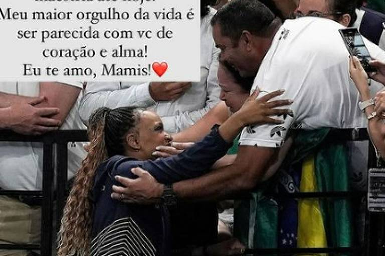 A imagem mostra uma celebração do Dia dos Pais, com uma mensagem carinhosa escrita em um quadro. A mensagem expressa gratidão e amor por um pai que desempenha o papel difícil de criar e educar. Há uma interação emocional entre uma mulher com cabelo cacheado e um homem, que parece ser seu pai, em um ambiente festivo. Ao fundo, outras pessoas estão sorrindo e aplaudindo. A imagem transmite um sentimento de amor e celebração familiar.