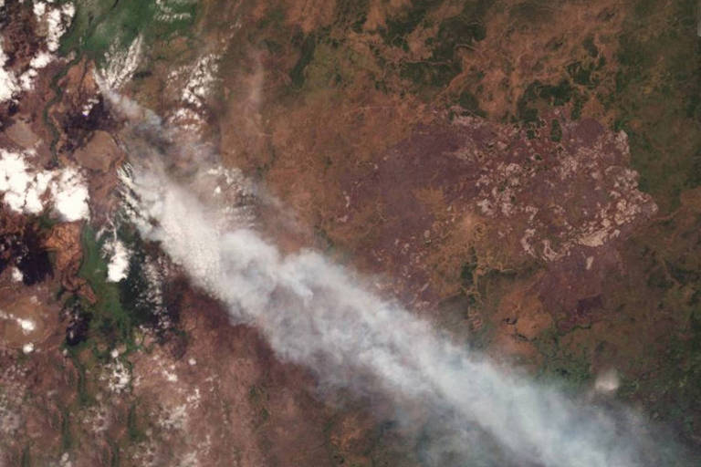 Imagem mostra fumaça branca em cima de terra com pouca vegetação