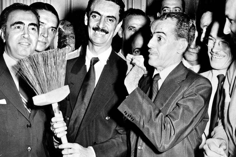 Jânio Quadros segura vassoura, seu símbolo de marketing, durante sua primeira passagem pela prefeitura de São Paulo, que se estendeu de 1953 a 1955; ele voltou a assumir o cargo em 1986