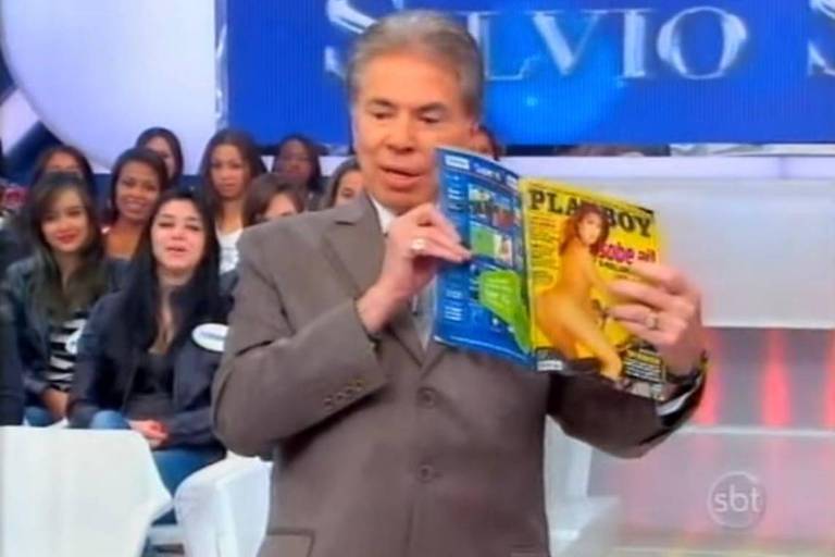 Homem de cabelos brancos e terno mostra revista