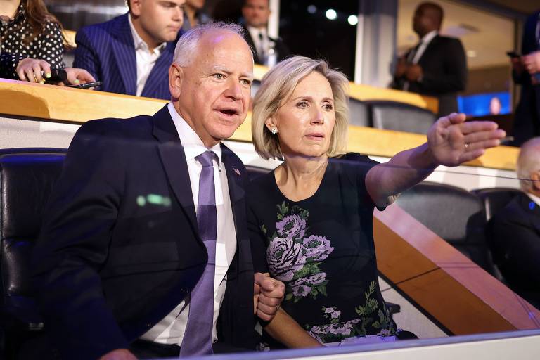 O governador de Minnesota e vice na chapa de Kamala, Tim Walz, assiste da plateia os discursos do primeiro dia da convenção ao lado da esposa, Gwen Walz