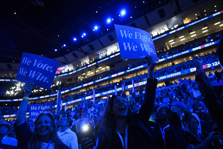 Apoiadores do Partido Democrata seguram cartazes em referência ao slogan de Kamala: "Quando lutamos, vencemos"
