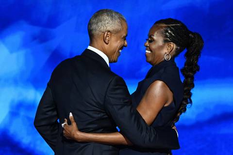 TOPSHOT - Former US President Barack Obama hugs his wife and former First Lady Michelle Obama after she introduced him on the second day of the Democratic National Convention (DNC) at the United Center in Chicago, Illinois, on August 20, 2024. Vice President Kamala Harris will formally accept the partys nomination for president at the DNC which runs from August 19-22 in Chicago. (Photo by Mandel NGAN / AFP)