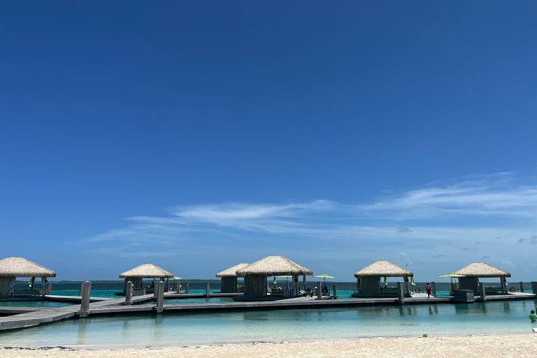 Praia com areia branca e água bem azul