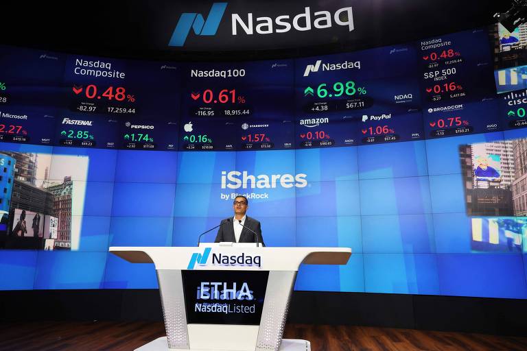 A imagem mostra o painel da Nasdaq com um apresentador em frente a um grande painel digital. O painel exibe informações financeiras, incluindo índices de ações e números em verde e vermelho, indicando variações de preços. O logotipo da Nasdaq é visível no fundo, e há uma mesa com o nome 'iShares' em destaque.