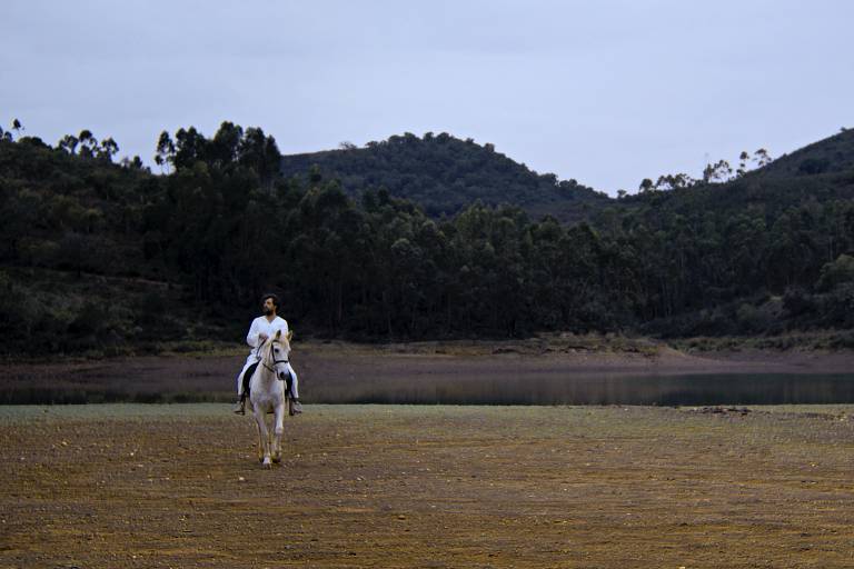 homem vestido de branco está montado em um cavalo