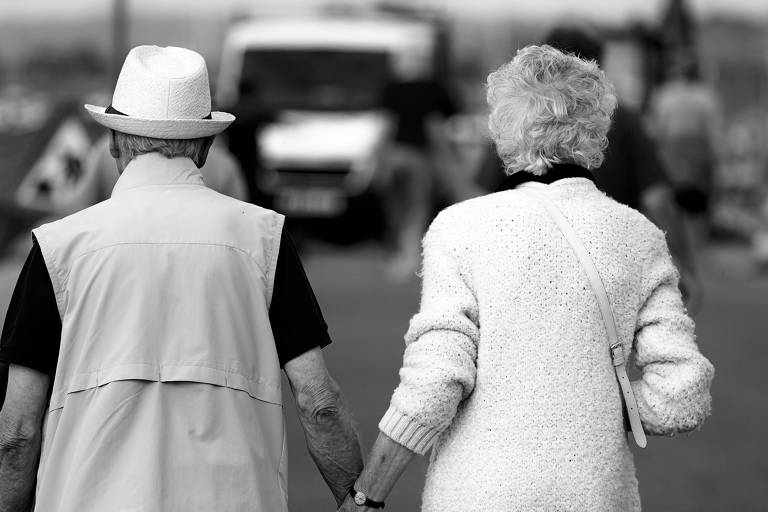 Casal, de costas, anda de mãos dadas