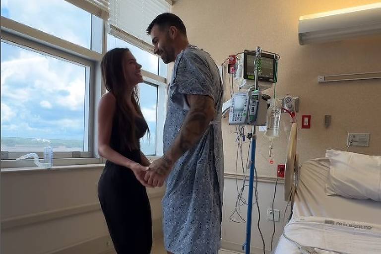 Em foto colorida, casal aparece dançando em um quarto de  hospital