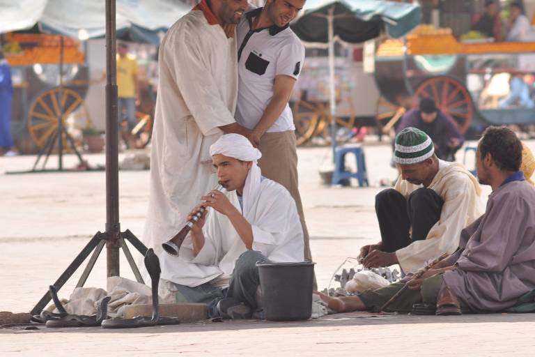 Encantador de serpentes em praça de Marrakech