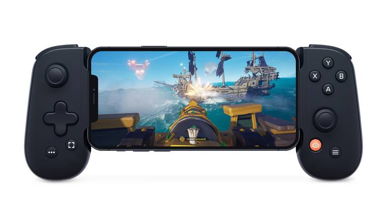 A imagem mostra um smartphone montado em um controle de videogame. A tela do smartphone exibe um jogo de piratas, com navios e uma cena de batalha no mar. O controle é preto, com botões e alavancas visíveis em ambos os lados do dispositivo.