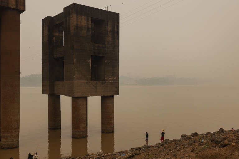 Moradores pescam sob a ponte do rio Madeira em Porto Velho, em meio a fumaça das queimadas que há dias cobre a capital de Rondônia