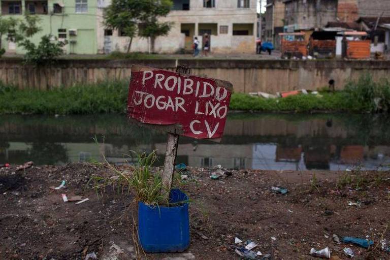 Um cartaz de "Proibido jogar lixo" assinado pelo Comando Vermelho, facção criminosa que controla a Cidade de Deus, favela onde a foto foi tirada em 2018