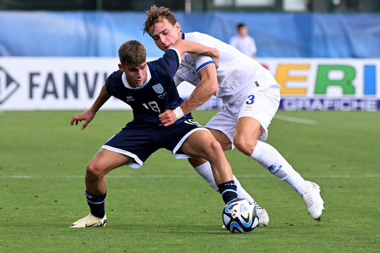 Usando uniforme azul escuro, Nicko Sensoli, de San Marino, protege a bola diante da marcação do cipriota Hector Kyprianou que veste branco, em amistoso entre os países