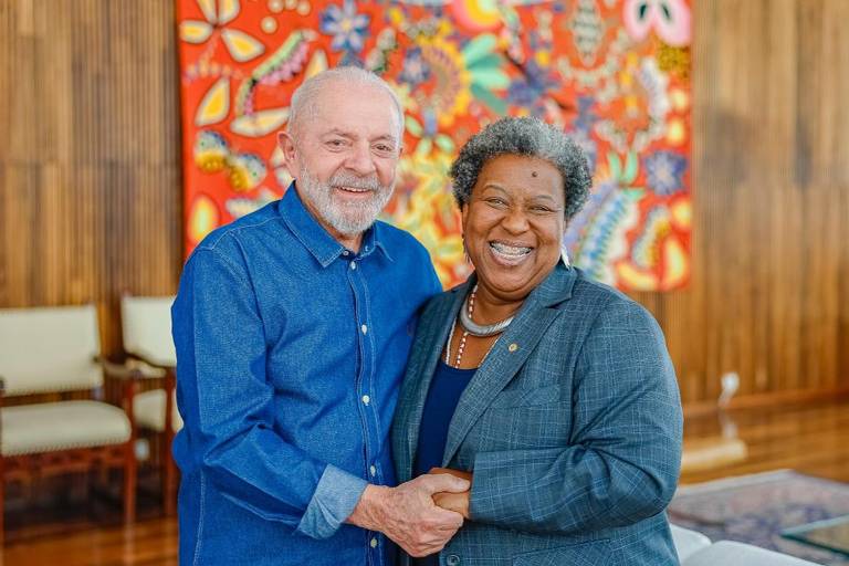 O presidente veste camisa azul e abraça a ministra em sala do palácio