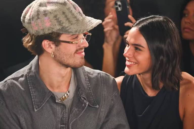 Em foto colorida, casal sorri enquanto são vistos juntos