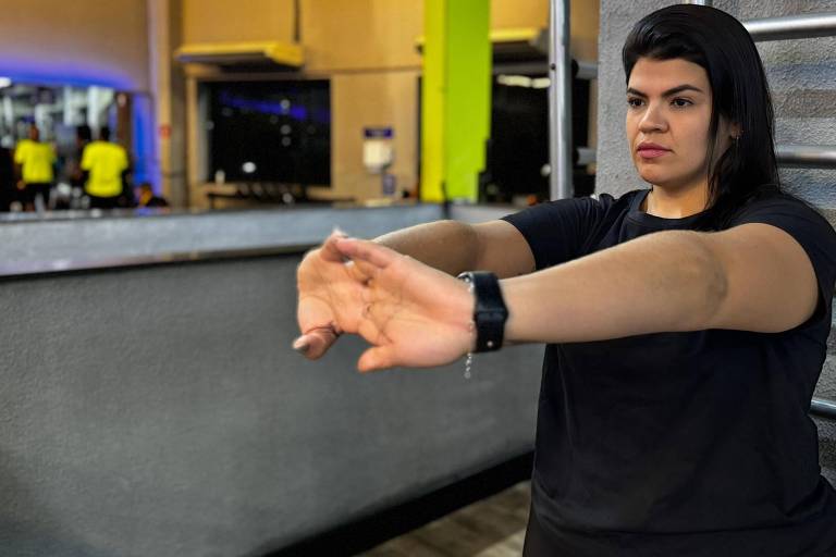 Mulher alongando os braços antes de fazer exercícios