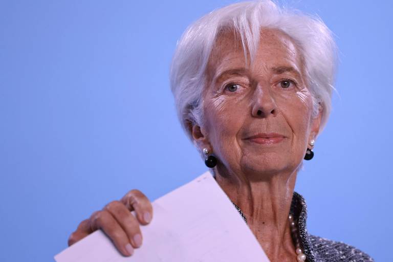 Christine Lagarde, presidente do BCE, segura um documento enquanto concede entrevista