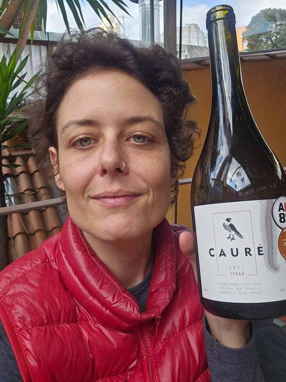 Mulher com uma garrafa de vinho na mão