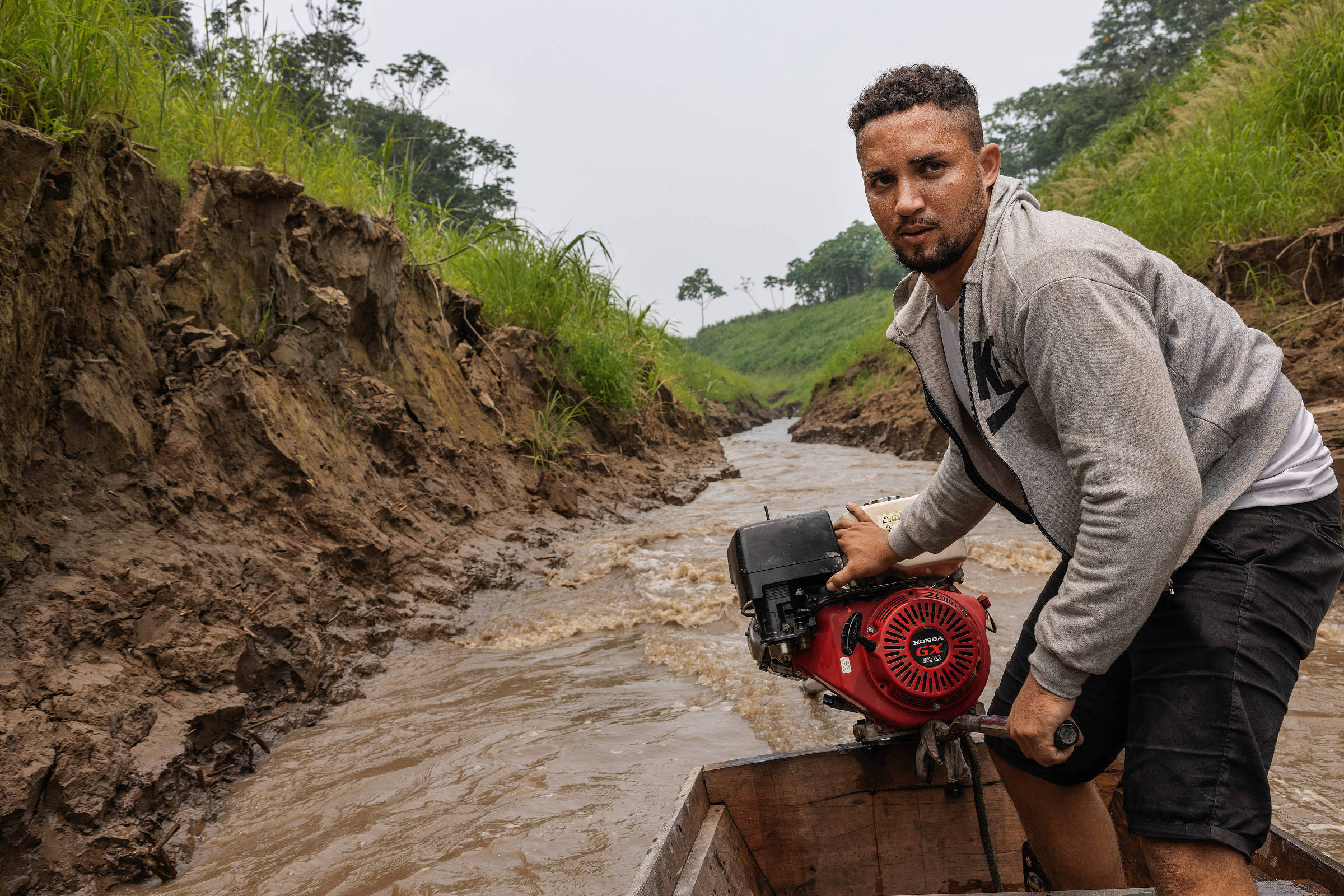 Ribeirinho conduz canoa por fio d'água