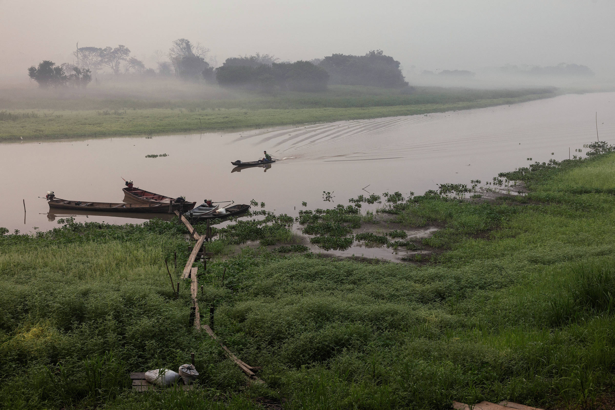 Ribeirinho em canoa em lago esvaziado