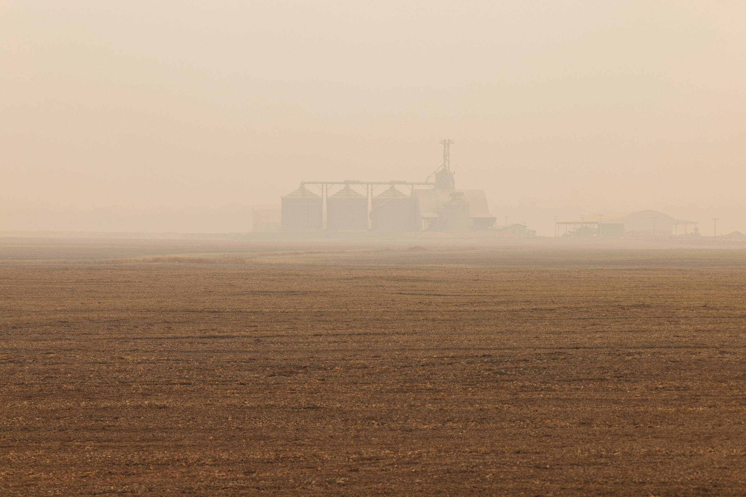 Silos de grãos em meio à fumaça