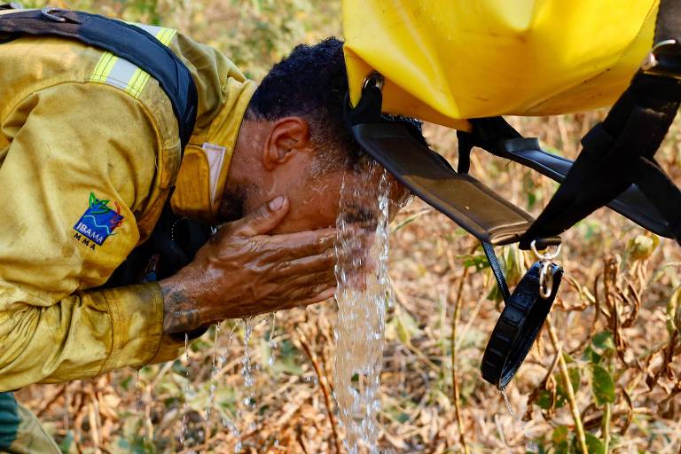 Brigadista toma água em meio a combate a incêndios