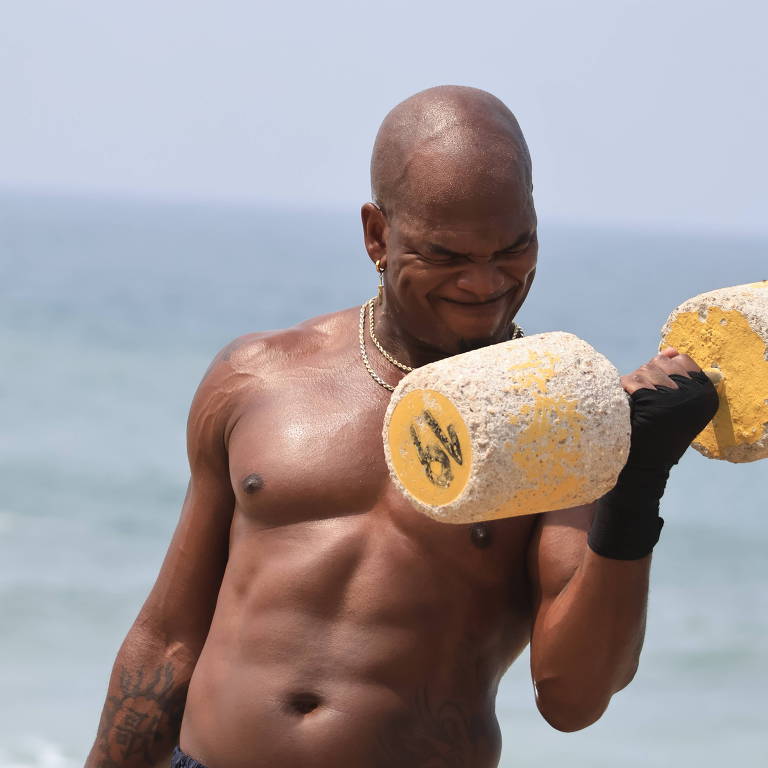 Ne-Yo levanta peso em praia do Rio