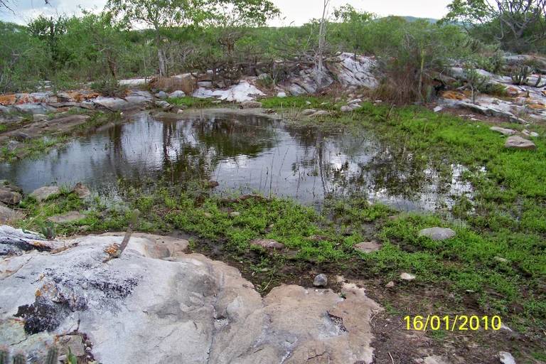 A imagem apresenta um mapa da América do Sul, destacando a localização de Alagoas (AL) e Bahia (BA) no Brasil. Ao lado, há uma fotografia de uma área de pesquisa arqueológica com água e vegetação. A parte inferior mostra várias peças arqueológicas