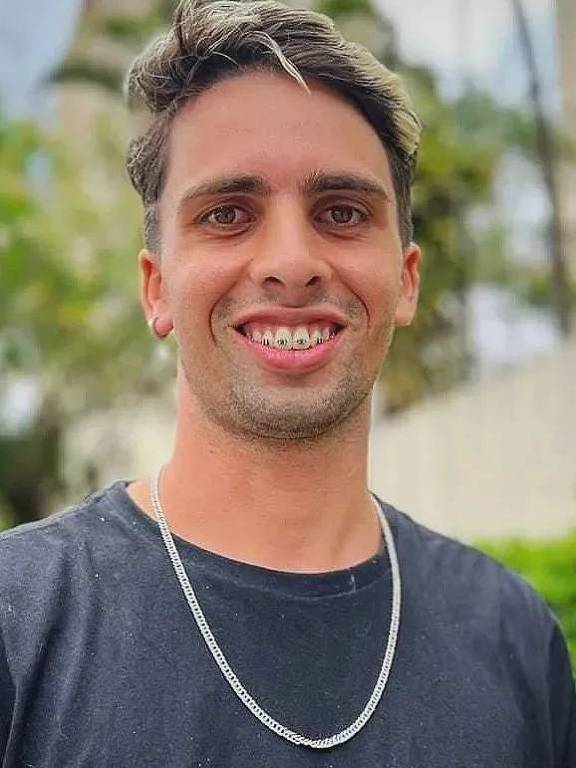 Um jovem sorridente está posando ao ar livre