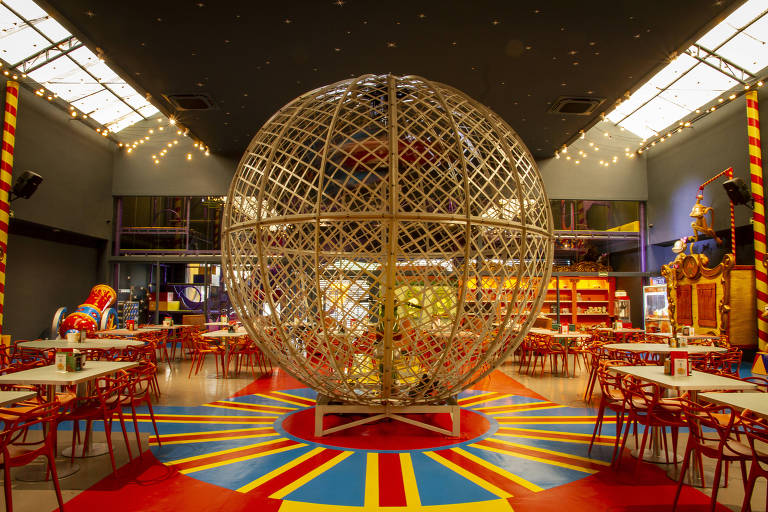 interior de uma pizzaria temática de circo com um globo da morte no meio