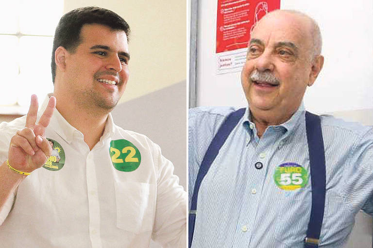 A imagem mostra dois homens em um ambiente interno. À esquerda, um homem sorridente, vestindo uma camisa branca, faz o sinal de paz com a mão direita e usa um adesivo verde com o número 22. À direita, um homem mais velho, também sorridente, usa uma camisa azul clara e suspensórios, com um adesivo verde com o número 55. Ambos parecem estar em um contexto de campanha eleitoral.