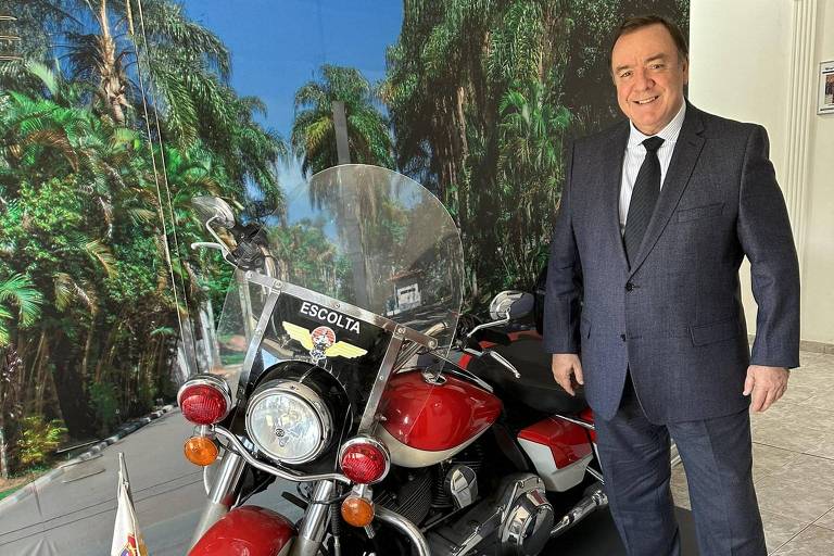Juiz militar posa ao lado de moto antiga da pM