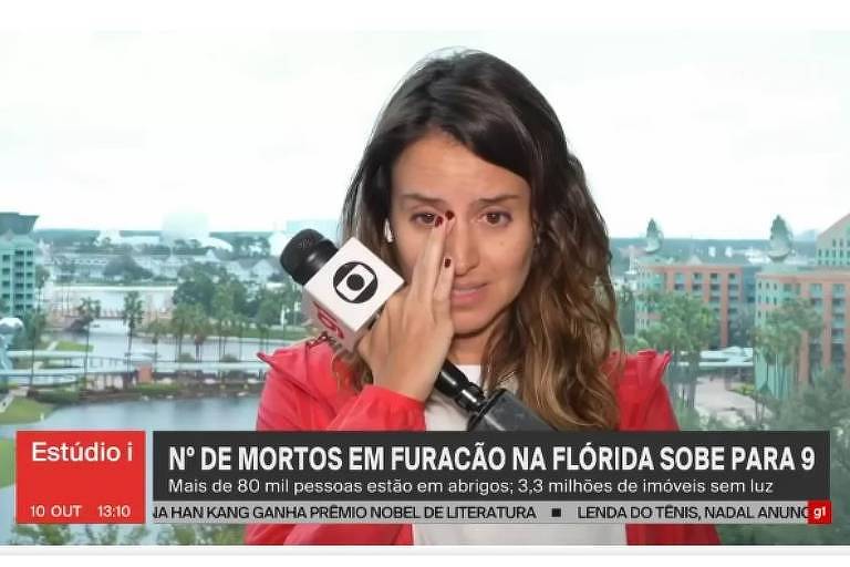 Mulher enxuga lágrimas com microfone na mão