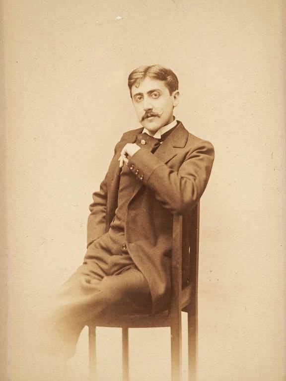 Marcel Proust, com olhar penetrante, sentado em uma cadeira