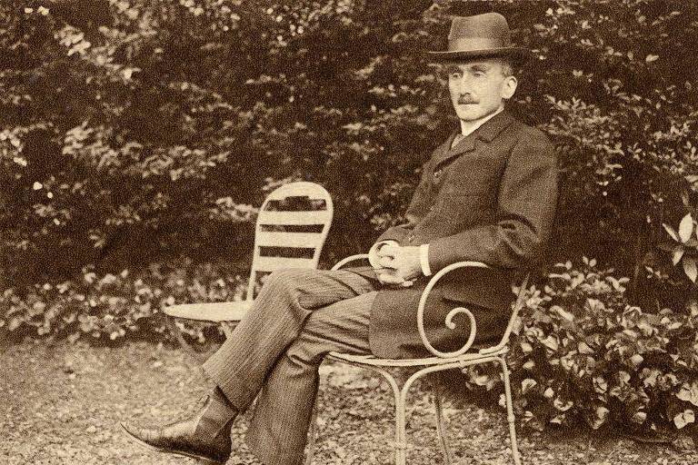 Bergson sentado em cadeira em área externa